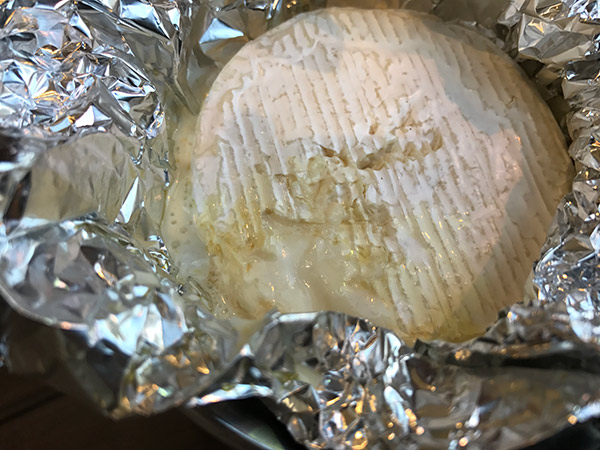 4.蓋を開け、アルミホイルを開くと…柔らかくなったチーズがトロ～リとなっているはずです。 （トロ～リなっていなかったら、もう少し蓋をしてみましょう）